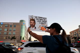 A protester holds up a sign that reads, ‘We stand with the king of late night comedy’